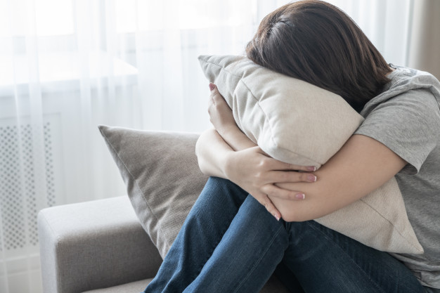 sad depressed woman home sitting couch hugging pillow loneliness sadness concept 130111 1759 - کمبود چه ویتامین‌هایی سبب تشدید افسردگی می‌شود؟